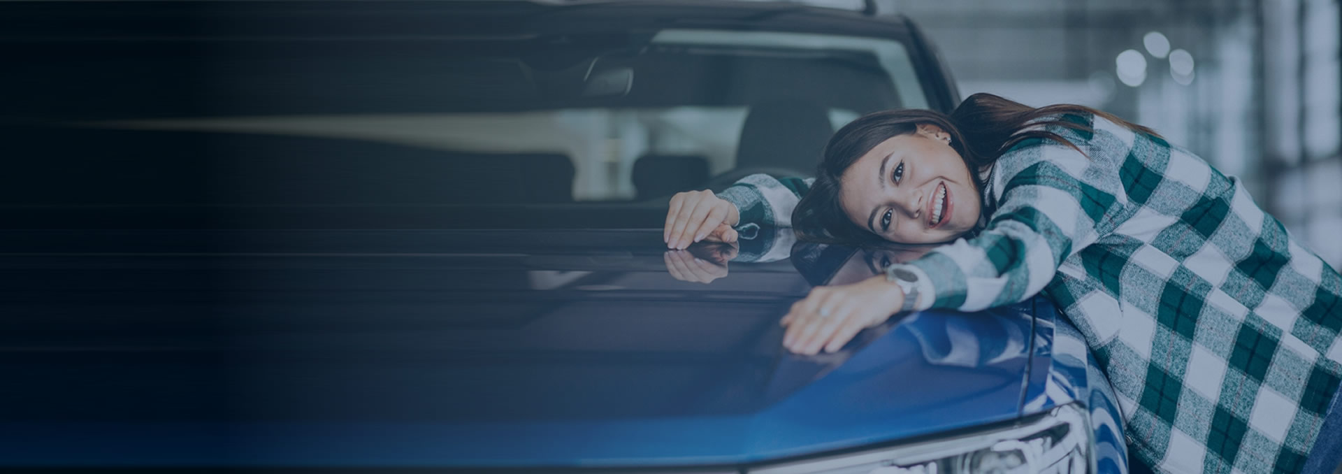 Mulher sorrindo ao lado de um automóvel azul