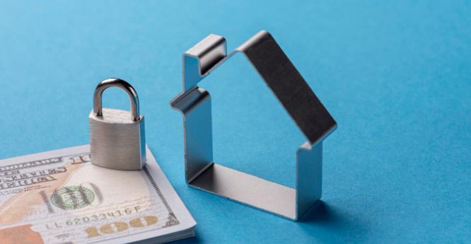 Miniatura de casa com um cadeado sobre notas de dinheiro